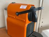 une machine à café orange posée sur une table à côté d'un évier