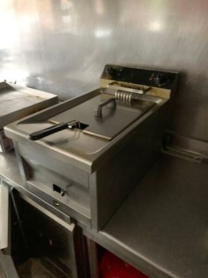 un plan de travail en acier inoxydable sur lequel est posée une friteuse électrique