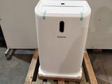 a white air purifier sitting on a pallet in a room