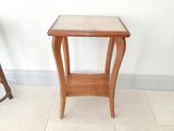 une petite table en bois avec un plateau en verre, posée sur un sol carrelé