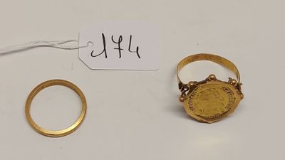 un gros plan d'une bague en or et d'une bague en or posée sur une table
