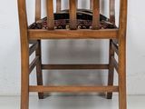 a wooden chair with a black seat on a white floor