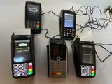 Plusieurs téléphones portables sont alignés sur une table, reliés par des fils.