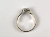 a close up of a diamond ring on a white surface