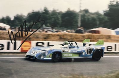 une photo dédicacée d'un homme au volant d'une voiture de course