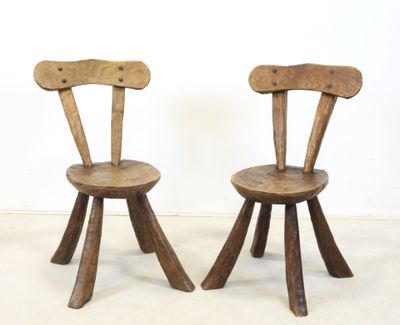 these are two wooden chairs sitting next to each other on a white floor