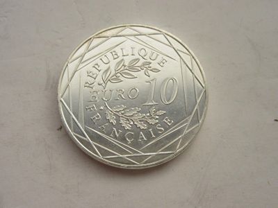 une pièce d'argent posée sur une table, sur fond blanc