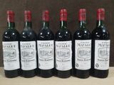 six bouteilles de vin rouge sont alignées sur une table en bois