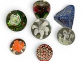 Plusieurs morceaux de verre de différentes couleurs sont disposés sur une surface blanche.