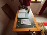 un bureau sur lequel se trouvent un ordinateur portable et des papiers, dans un coin de la pièce
