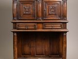 an antique oak cupboard with carved panels and drawers