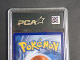 a pokemon card in a plastic case on a table