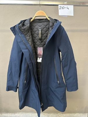 une veste suspendue à un cintre devant un mur, avec une étiquette de prix