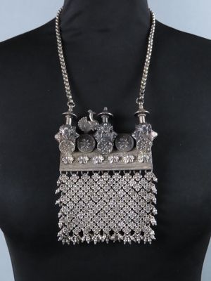 une femme portant un collier composé de perles en argent et d'une chaîne