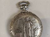 a silver pocket watch with a picture of a man and a dog on it