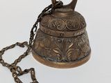 a bell with a chain around it on a white surface