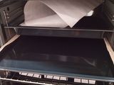 an open oven door with a sheet of paper in it