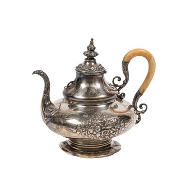 une théière ancienne en argent avec une anse en bois, sur fond blanc