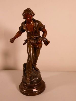 bronze statue of a man holding a bird on top of a wooden base