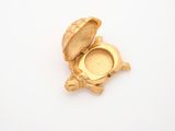 a gold locke with a turtle on it on a white surface