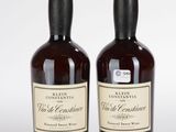 deux bouteilles de vin posées l'une à côté de l'autre sur une surface blanche