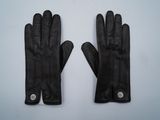 une paire de gants en cuir noir posée sur une surface blanche