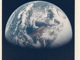 une vieille photo de la Terre prise depuis l'espace, avec la Lune en arrière-plan