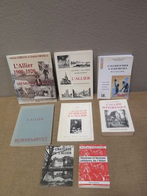 several books are sitting on a table in front of a wall