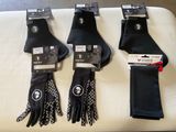 three pairs of black gloves and a pair of black gloves on a white table