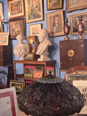 de nombreux tableaux accrochés aux murs d'une pièce où l'on trouve de nombreuses œuvres d'art accrochées aux murs
