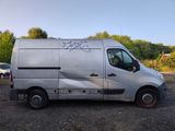 a silver van with graffiti on it parked in a parking lot
