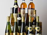 many bottles of wine sitting on a wooden table