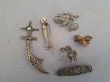 de nombreuses broches en argent sur un fond blanc