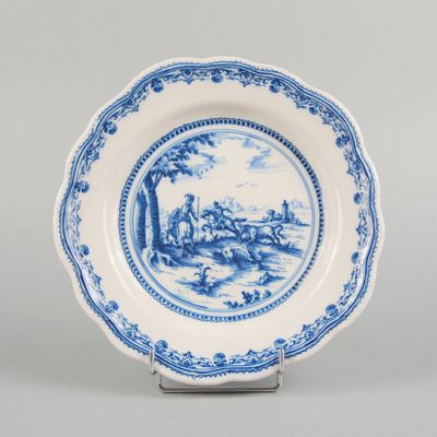 a blue and white plate with a landscape scene on it