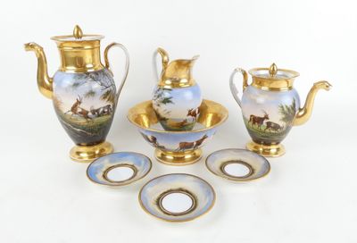 quatre objets différents en porcelaine et en or posés sur la table