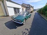 a green car parked on the side of the road