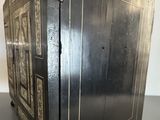 an old black metal cabinet with a door on top of it