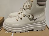 the white boots are on top of a cardboard box on the floor