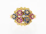 a close up of a gold ring with blue, pink and white stones