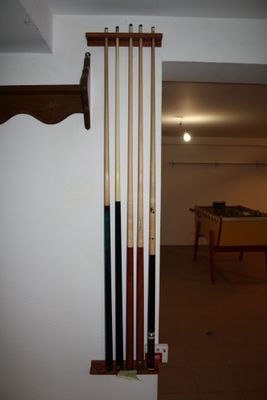 a picture of a room with a pool table and a rack of cues