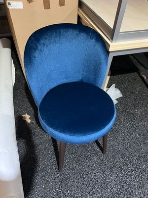 a blue chair sitting next to a white chair in a room