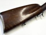 an old rifle with a wooden barrel on a white surface