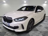 the white bmw m140i sports wagon is parked in a showroom