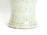 a close up of a vase on a white surface