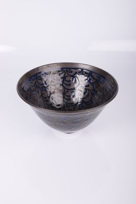 a black and blue bowl sitting on a white surface