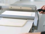 une personne en train de découper un morceau de papier à l'aide d'une machine