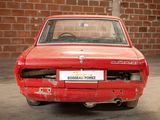 a red car that is parked in front of a brick wall