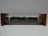 un train miniature dans une vitrine posée sur une table