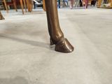 a bronze statue of a horse ' s foot on the floor