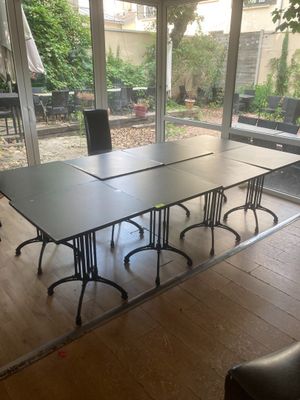 une table et des chaises dans une pièce dotée de grandes fenêtres